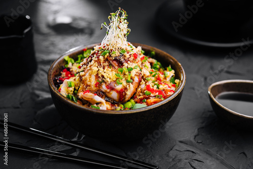 Salad with eel and couscous on black bowl photo