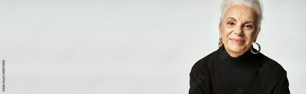 business portrait banner, happy middle aged business woman in turtleneck looking away on grey
