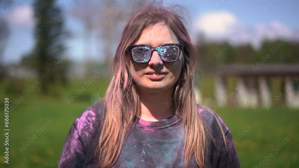 Happy smiling girl with holi color on face tuning by holding holi plate while looking at camera Happy smiling girl with holi color on face tuning by holding holi plate while looking at camera