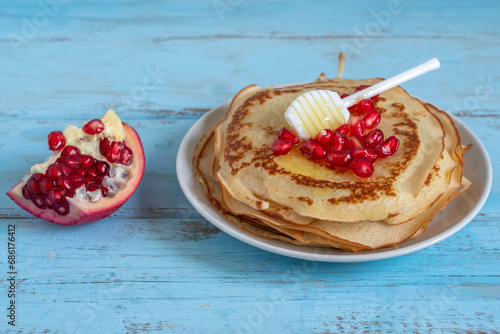 French crepes with fresh honey and pomegranate seeds.
