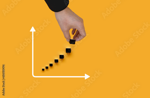 Wooden cube blocks with percentage sign and down arrow with stack of coins. For financial recession crisis, interest rate decline, investment reduce, risk management concept