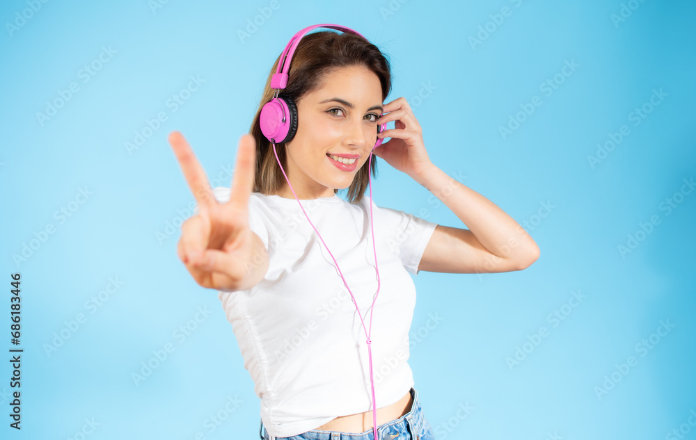 Young happy woman wear light shirt casual clothes yellow headphones listen to music dance look aside on area isolated on plaint pastel blue background studio portrait. Lifestyle concept Young happy woman wear light shirt casual clothes yellow headphones listen to music dance look aside on area isolated on plaint pastel blue background studio portrait. Lifestyle concept