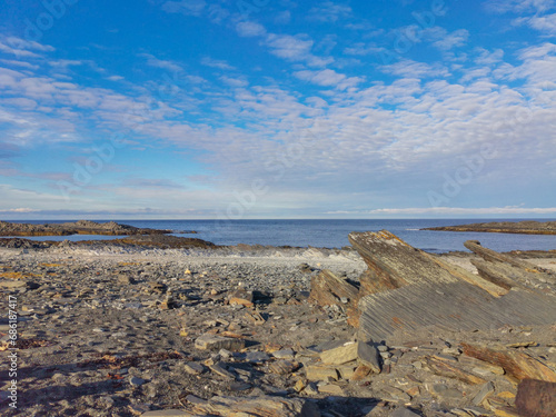 The rocky coast of the Barents Sea. Beautiful view of the rocks and the coast of the Rybachy and Sredny peninsulas, Murmansk region, Russia. The landscape is the harsh beauty of the north. photo