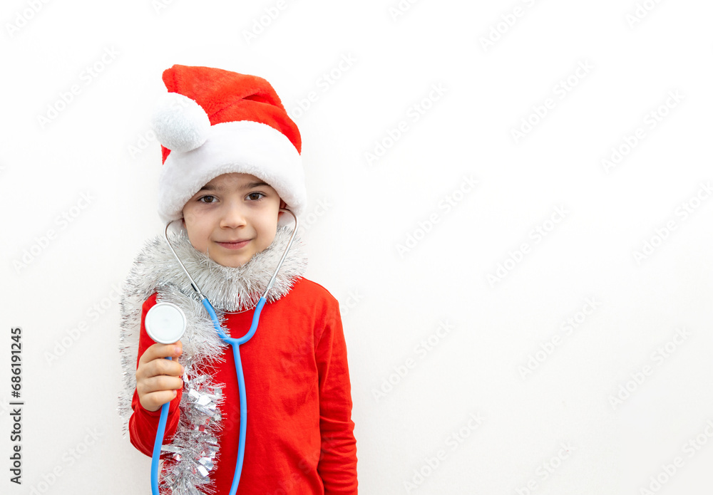 cute boy with santa claus cap and stethoscope playing with teddy bear,listening patient breathing,heartbeat.preschooler kid in red clothes with garland and tangerine covering eyes.candy cane as heart cute boy with santa claus cap and stethoscope playing with teddy bear,listening patient breathing,heartbeat.preschooler kid in red clothes with garland and tangerine covering eyes.candy cane as heart