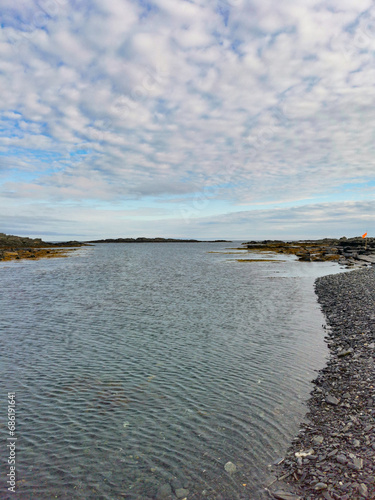 The rocky coast of the Barents Sea. Beautiful view of the rocks and the coast of the Rybachy and Sredny peninsulas, Murmansk region, Russia. The landscape is the harsh beauty of the north. photo