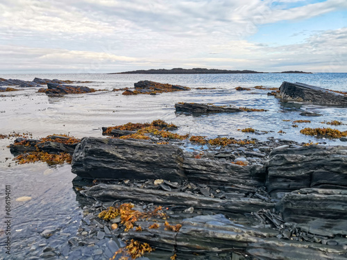 The rocky coast of the Barents Sea. Beautiful view of the rocks and the coast of the Rybachy and Sredny peninsulas, Murmansk region, Russia. The landscape is the harsh beauty of the north. photo