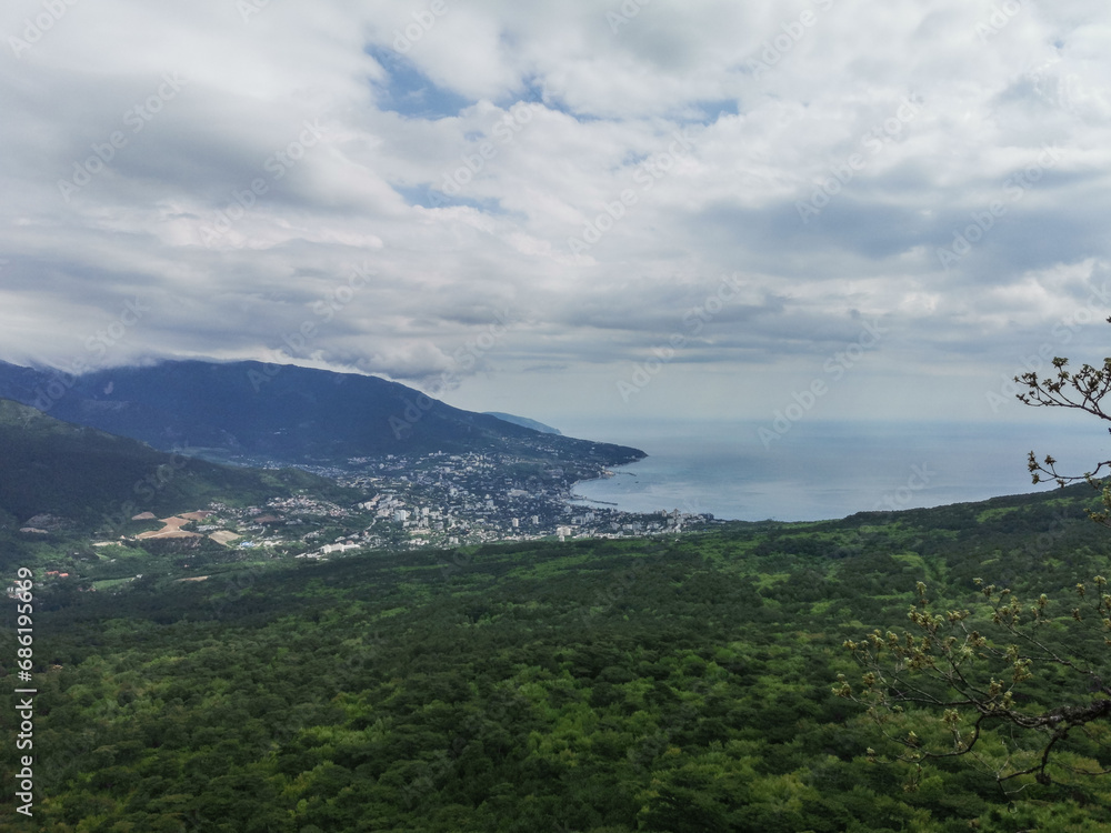 Picturesque view of the city of Yalta and the Black Sea from Ai-Petri mountain in Crimea. Mountain landscape with trees in the clouds. Clouds over Ai-Petri Mountain. Crimean Peninsula