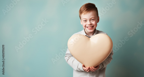 teenager with Down syndrome smiles and holds a heart-shaped figure. People with disabilities. photo