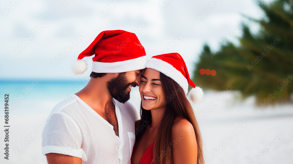 Obraz premium Couple in Santa hats celebrating Christmas on a tropical beach. 