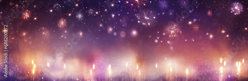 Candles on a bright background with firework bursting over it photo