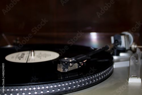Old gramophone turntable with disc. Playing vinyl close up with needle on the record.
