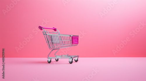 ピンクの背景にピンクのショッピングカートのミニチュア photo