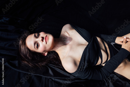 Beautiful slender woman in black lingerie in bedroom on bed