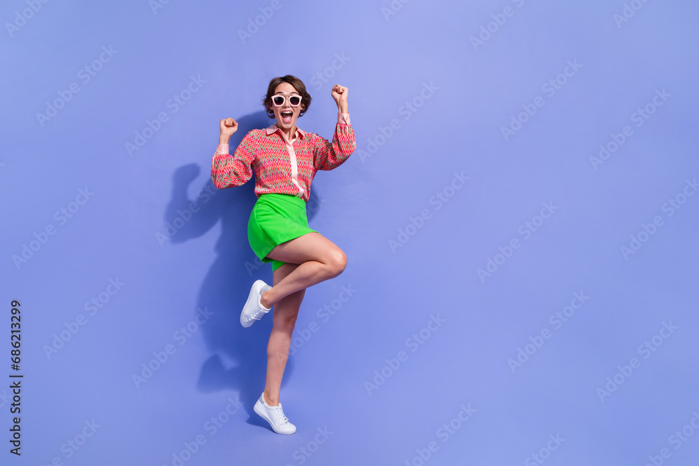 Full size photo of ecstatic overjoyed woman dressed print shirt in sunglass win betting scream yeah isolated on blue color background