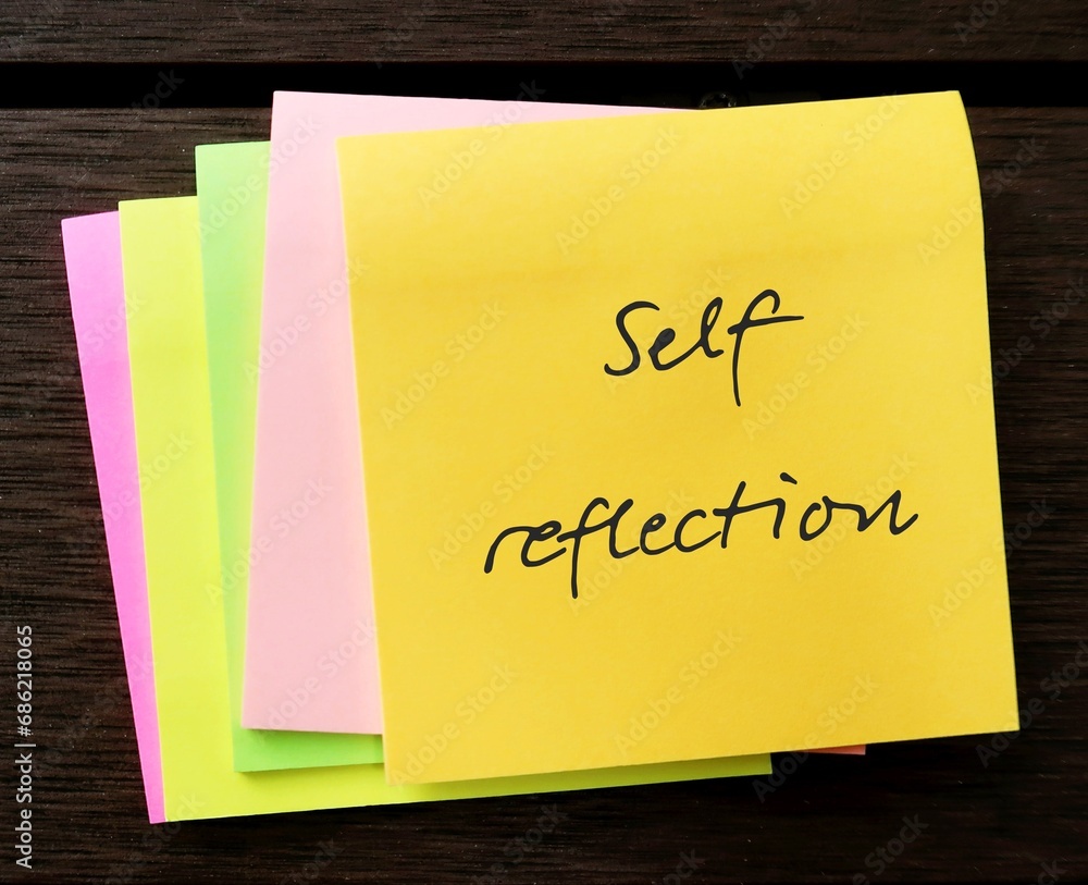 Note pad with handwritten text SELF REFLECTION, mental process to grow self understanding of who you are, values and why you think, feel, act the way you do
