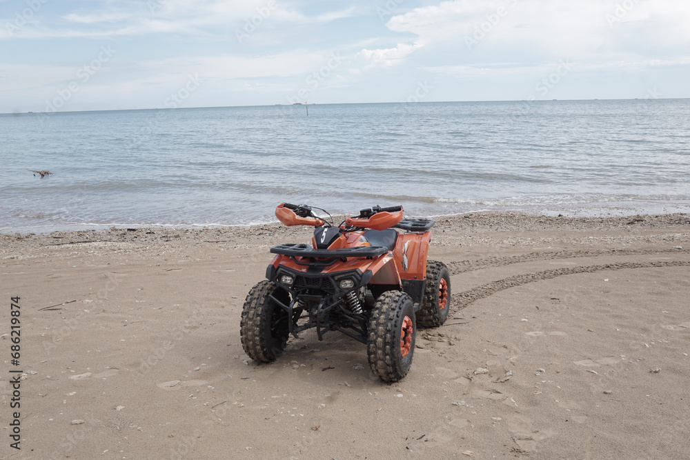 Obraz premium ATV Parked at seashore on clean beach with beautiful skies