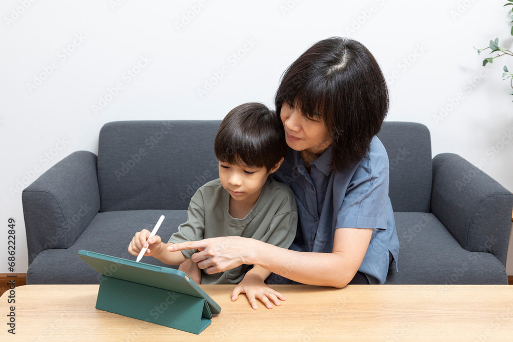 Asian woman mother use digital tablet with her son at home. Asian woman mother use digital tablet with her son at home.