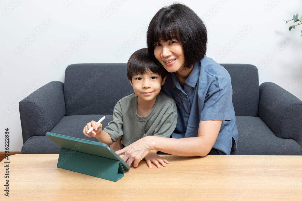 Asian woman mother use digital tablet with her son at home. Asian woman mother use digital tablet with her son at home.
