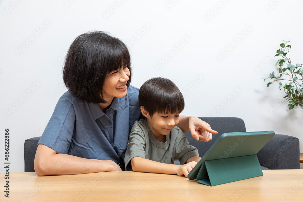 Asian woman mother use digital tablet with her son at home. Asian woman mother use digital tablet with her son at home.