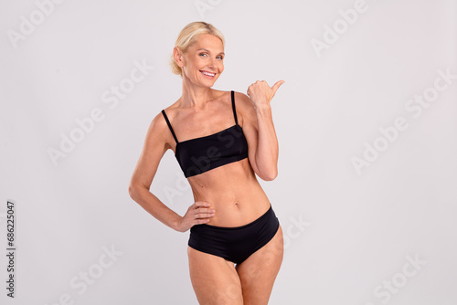 Photo of happy mature model sportive fit bodycadre lady posing direct finger novelty yoga studio advert isolated on gray color background © deagreez