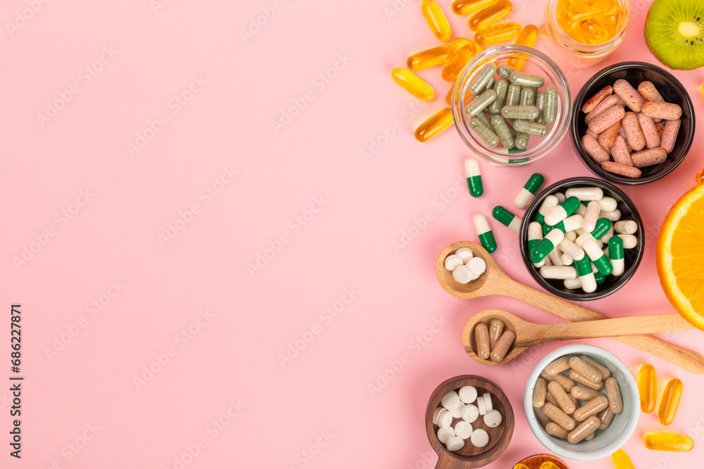 Vitamins and supplements. Variety of vitamin tablets in bowls on a pink background. Multivitamin complex for every day. Nutritional supplements.Copy space.Vitamins for immunity