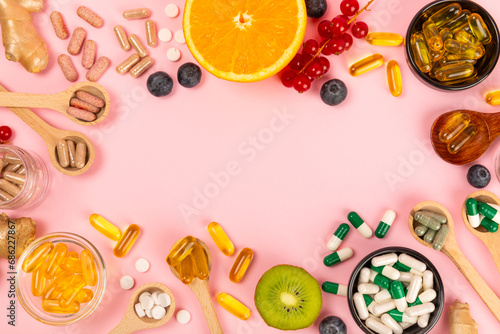 Vitamins and supplements. Variety of vitamin tablets in bowls on a pink background. Multivitamin complex for every day. Nutritional supplements.Copy space.Vitamins for immunity
