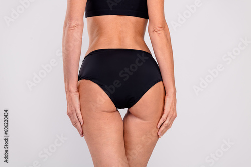 Cropped rear behind photo of sporty lady hands touch great shape hips isolated on grey color background