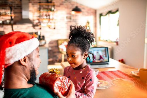 Father giving christmas present to little daughter at home photo