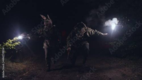 Soldier in a scary mask. 
A terrorist in a scary mask holds a lit flare. scary moment
 photo