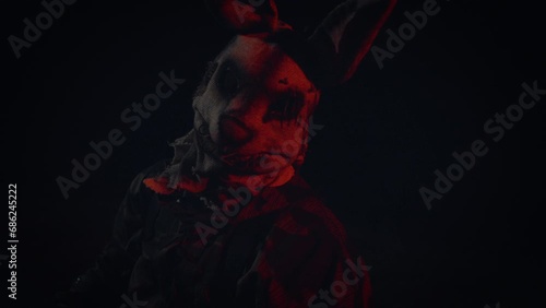 Soldier in a scary mask. A scary rabbit mask illuminated by a blinking light in a dark forest.
