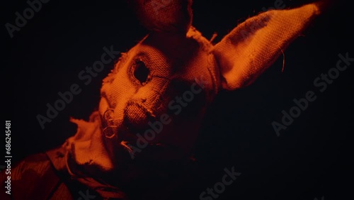Soldier in a scary mask. A scary rabbit mask illuminated by a blinking light in a dark forest.
