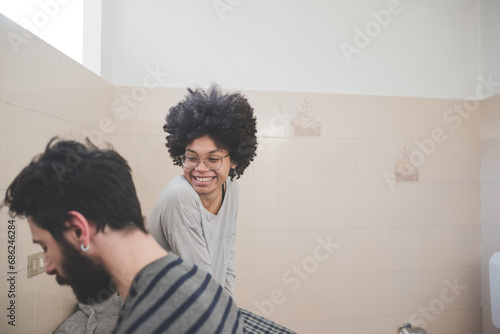Young multiethnic millennials couple spending morning routine in bathroom together photo