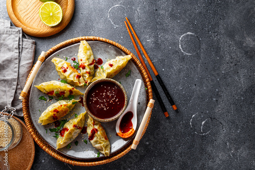 Asian dumplings with hot sauce on the grey background top view copy space for text