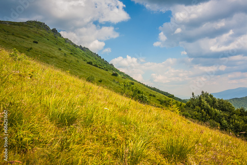 Beautiful view of the Ukrainian Carpathians to the mountains and valleys. Rain clouds in the mountains. Yellow and green grass, and the top of the mountain and the path to it