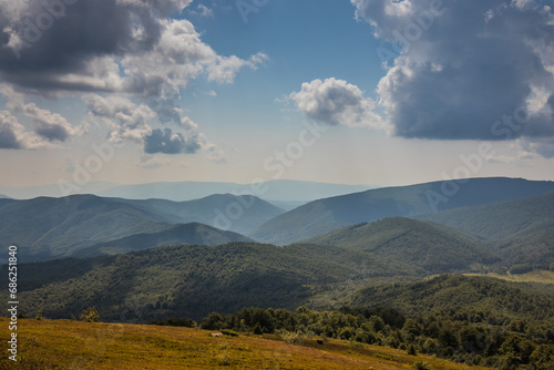 Beautiful view of the Ukrainian Carpathians to the mountains and valleys. Rain clouds in the mountains. Yellow and green grass, and the top of the mountain and the path to it