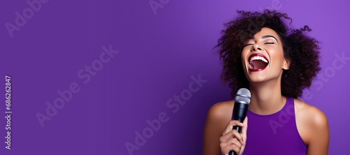 Young Woman Singing into a Microphone on a Purple Background with Space for Copy