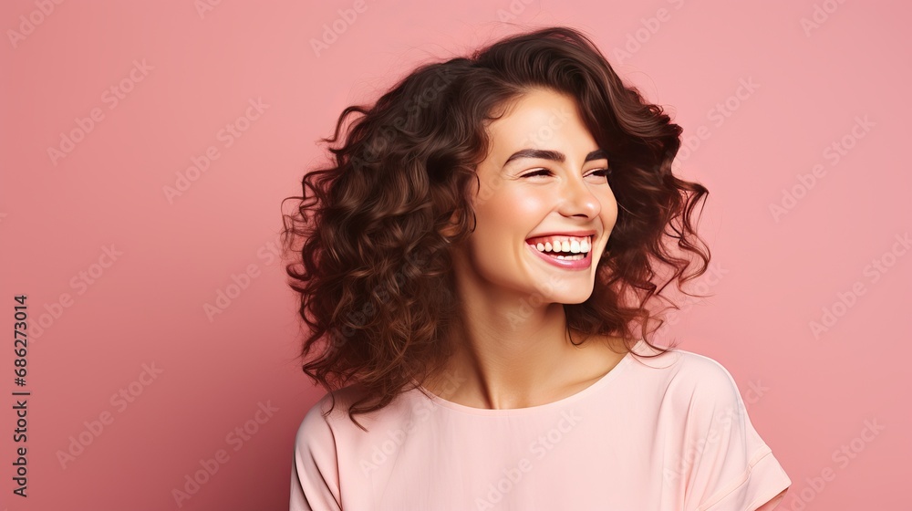 Inside, a cute and beautiful woman with wavy hair is laughing while taking an indoor photo in a pink blouse. Inside, a cute and beautiful woman with wavy hair is laughing while taking an indoor photo in a pink blouse.