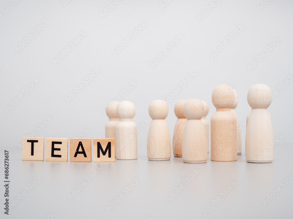 Wooden figures. The word TEAM and wooden figures on a gray background. Teamwork concept. Wooden figures. The word TEAM and wooden figures on a gray background. Teamwork concept.