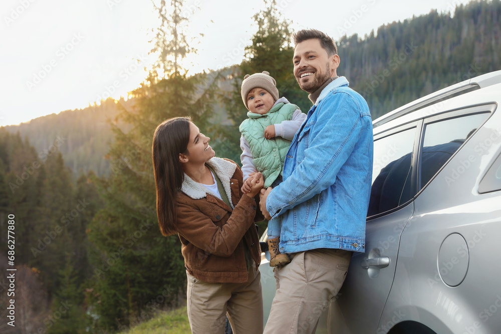© New Africa - Parents and their daughter near car in mountains. Family traveling