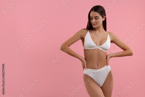 Young woman in stylish white bikini on pink background. Space for text