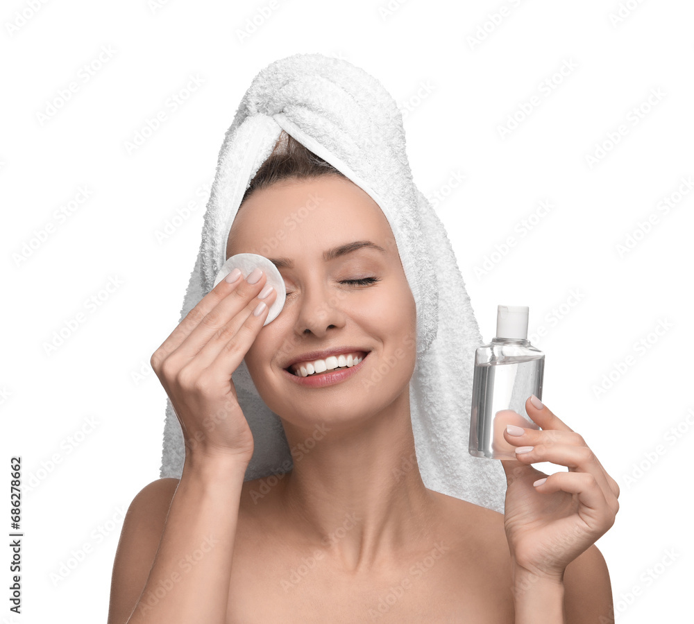 Smiling woman removing makeup with cotton pad and holding bottle on white background Smiling woman removing makeup with cotton pad and holding bottle on white background