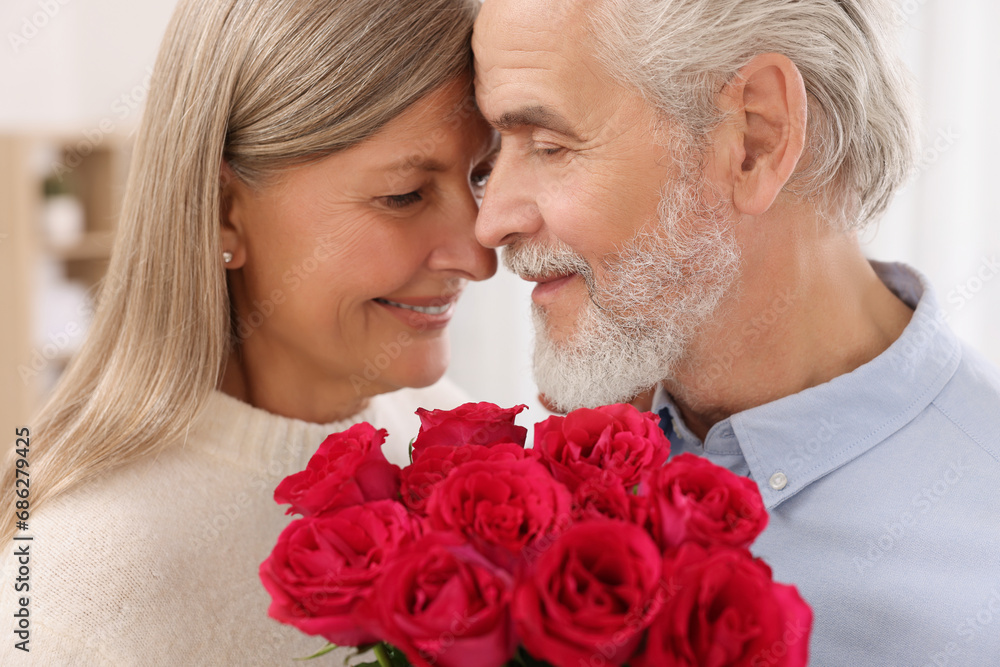 Affectionate senior couple with beautiful bouquet at home Affectionate senior couple with beautiful bouquet at home