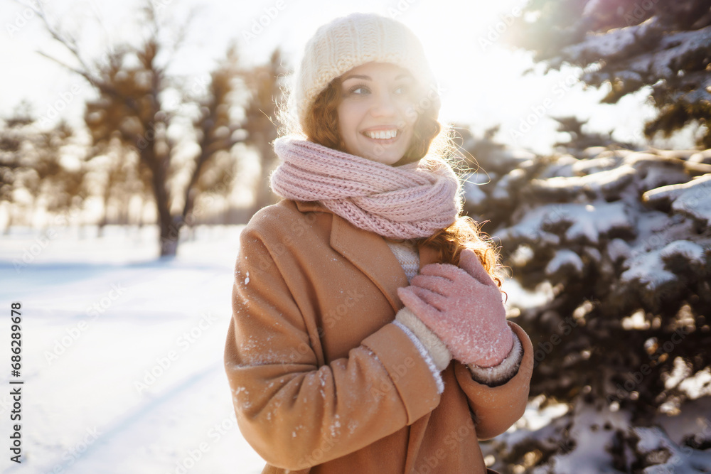 Obraz premium Winter women's fun. Young woman having fun, walking in a winter snowy park. Concept of weekend, vacation. Lifestyle.