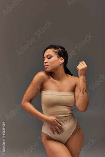 young attractive african american woman in beige pastel underwear posing seriously, fashion concept