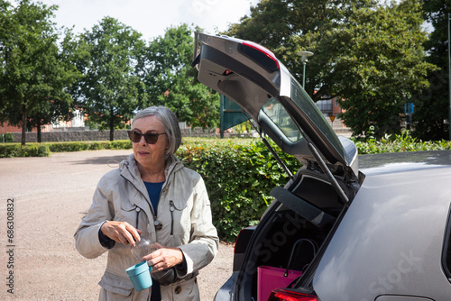 elderly woman next to car 