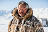 Smiling Inuit man in traditional fur coat with snowscape