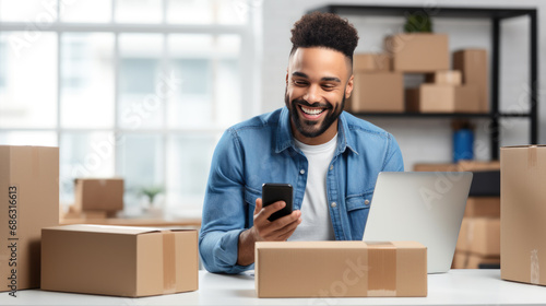 Man is smiling and using a laptop among shelves stocked with cardboard boxes in what appears to be a small business warehouse setting. © MP Studio