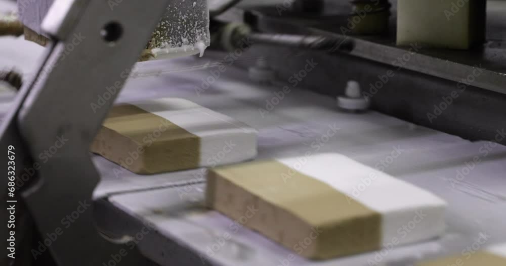 Food industry. Automation and technology. Closeup view of a machine slicing cream and dulce de leche ice cream. Food industry. Automation and technology. Closeup view of a machine slicing cream and dulce de leche ice cream.