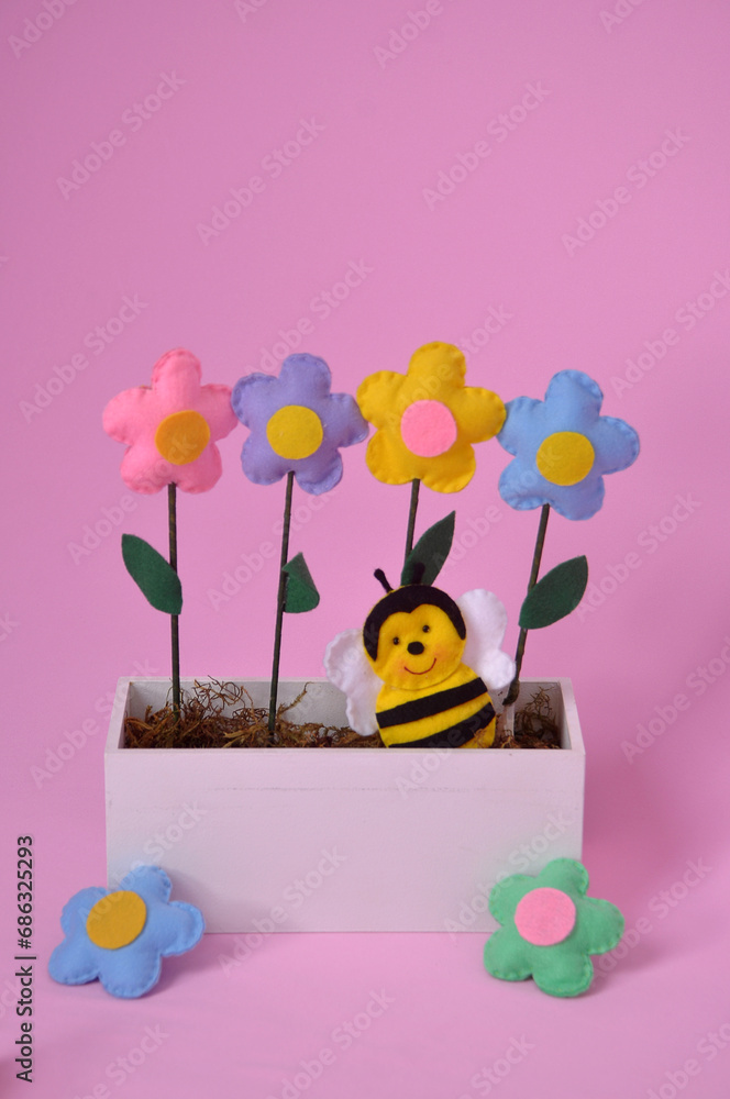 Fototapeta premium abelha no jardim de flores coloridas de feltro em fundo rosa 