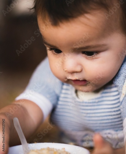 Latin little boy eating porridge, face closeup